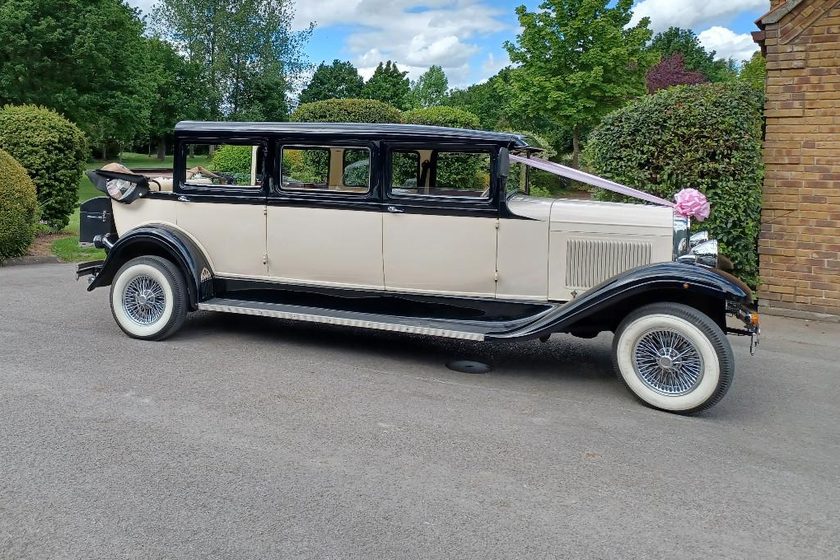 Side view of the ivory and black Ford Bramwith, dressed with a pink bow.